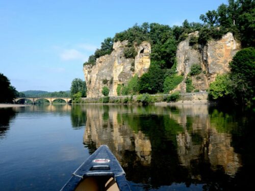 Promenade sur la Dordogne avec vue sur les falaises et un pont d’architecture périgourdine.