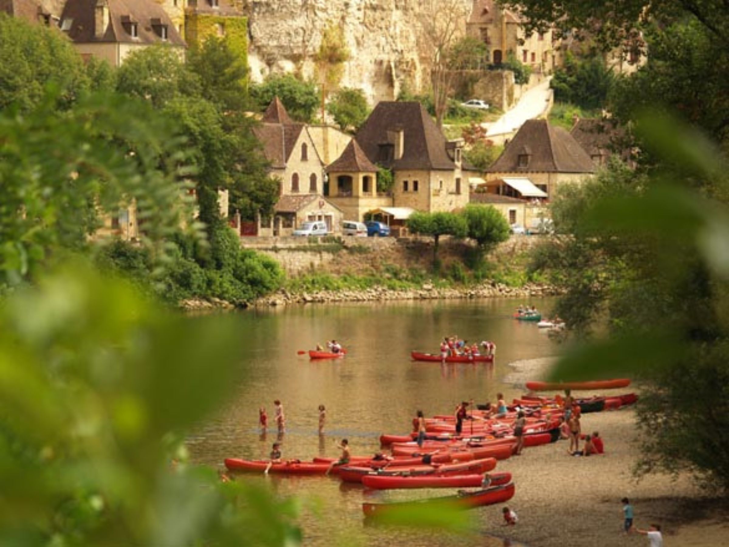 Vacanciers en canoë se baignant dans la Dordogne aux abords de la Roque-Gageac.